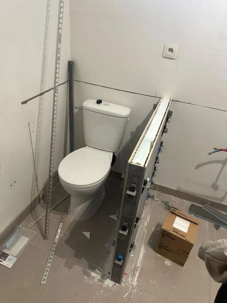 Rénovation de WC en cours, cloison du bâti-support carrelée en cours de pose